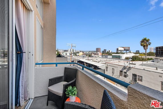 Balcony view of urban surroundings with buildings and clear sky.