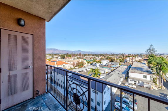 View from a balcony overlooking a cityscape with mountains in the background.
