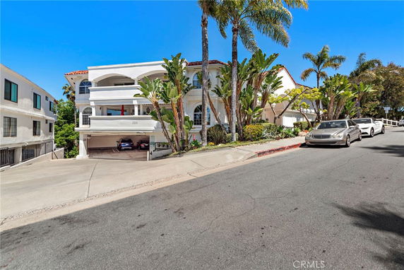 Front view of a two-story house with balconies and an open garage.