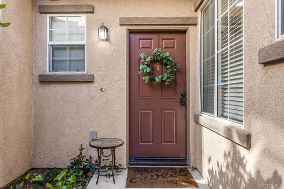 Front view of a house entrance with a decorative wreath on the door.