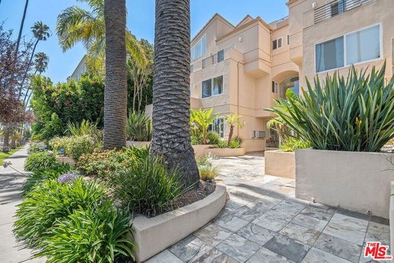 Front view of a multi-story residential building with landscaped garden.