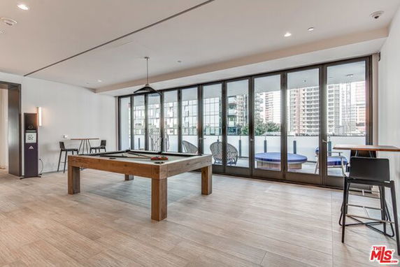 Indoor recreation room with a billiards table and large windows.