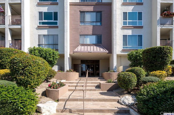 Front view of a multi-story building with a landscaped entrance.