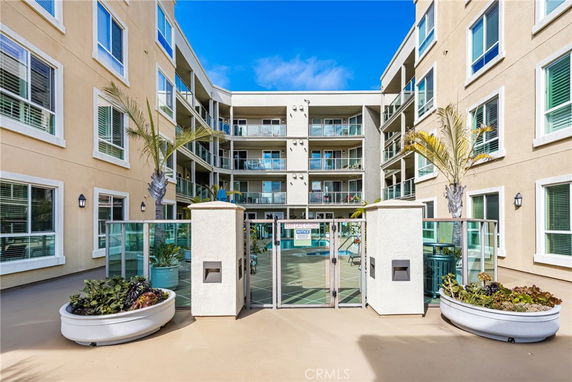 Front view of a multi-story residential building with balconies and glass railings.
