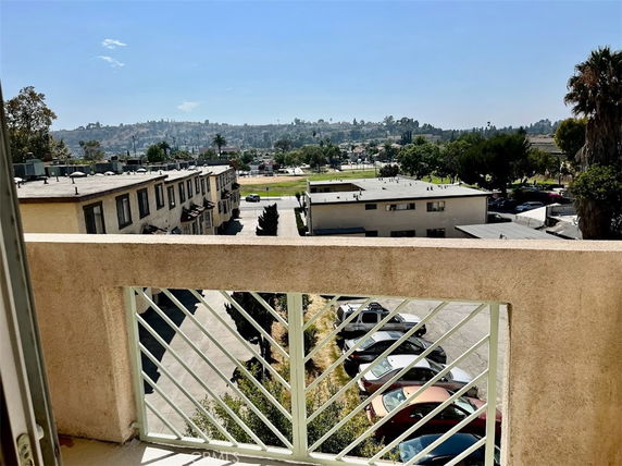 View from a building balcony showing surrounding buildings and a distant landscape.