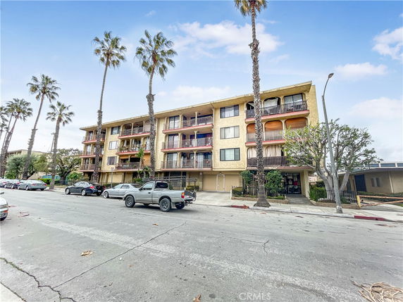 Front view of a multi-story apartment building with balconies.
