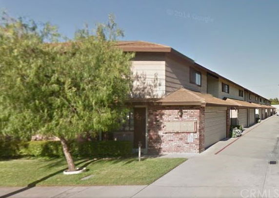 Front view of a two-story townhouse with brick exterior and a garage.
