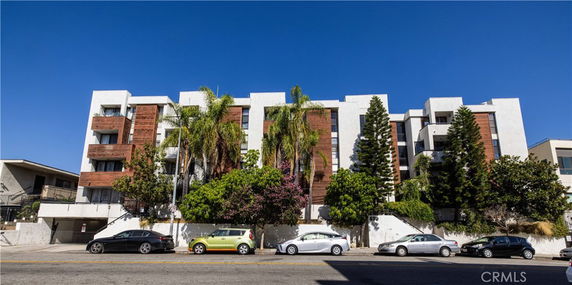 Front view of a multi-story residential building with balconies and modern design.