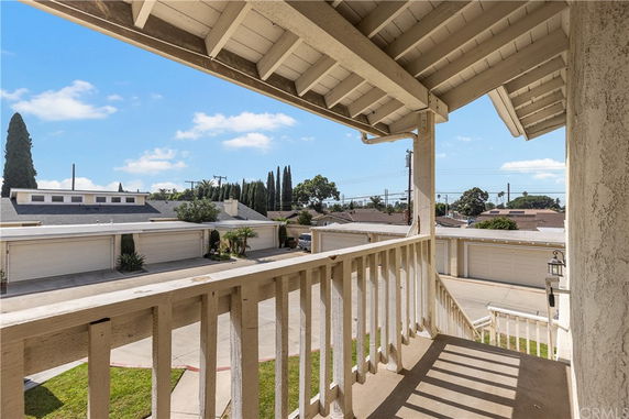 View from a balcony showing a residential area with garages and rooftops.