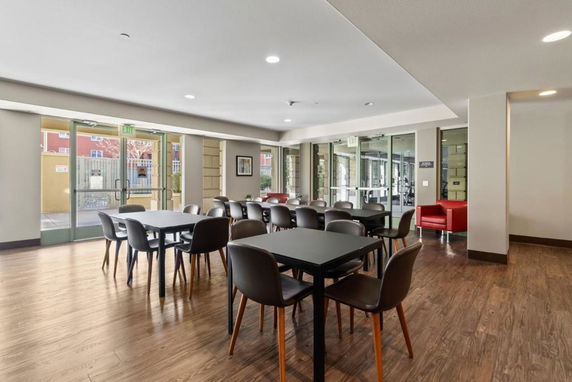 Interior view of a clubhouse with tables and chairs arranged in a communal space.