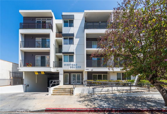Front view of a modern multi-story apartment building with balconies.