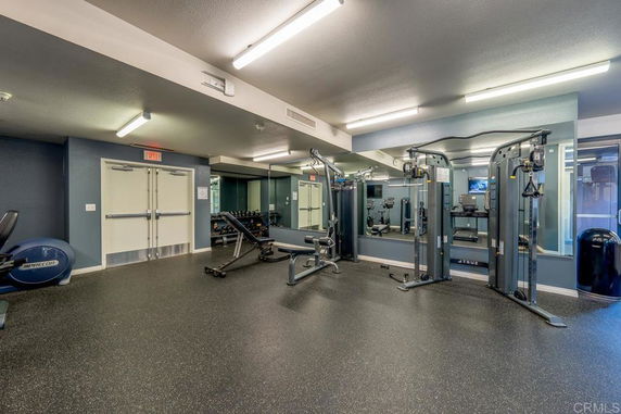 Indoor gym area with exercise equipment and mirrors.