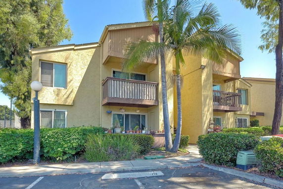 Front view of a multi-story apartment building with balconies.
