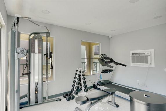 Indoor gym area with exercise equipment including a treadmill and weights.