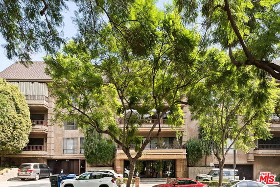 Front view of a multi-story building with balconies and an entrance.