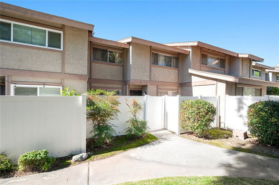 Front view of a multi-story townhouse with a gated entrance.