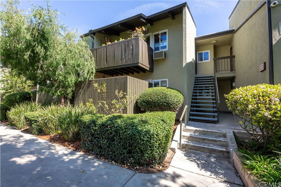 Front view of a two-story residential building with stairs leading to the upper level.