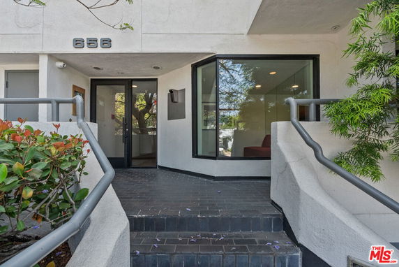 Front view of a building entrance with a glass door and large window.