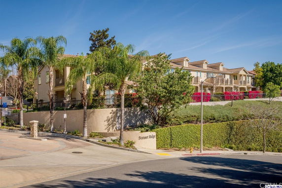 Front view of a residential building complex with a landscaped entrance.