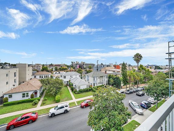 Panoramic view of a suburban neighborhood with houses and streets, seen from an elevated perspective.