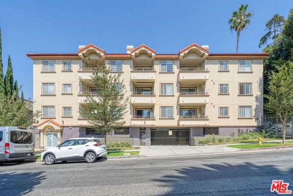 Front view of a four-story apartment building with balconies.