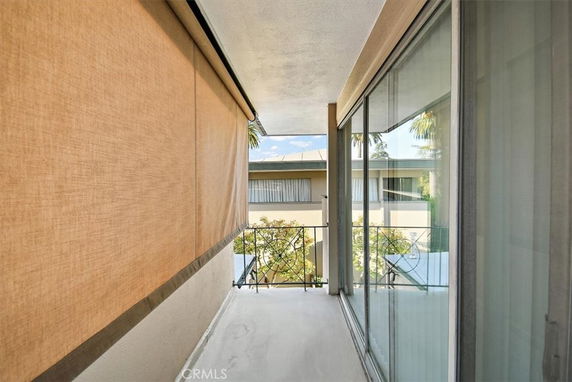 Balcony view with sliding glass doors and visible building in the background.