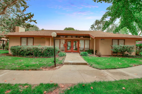 Front view of a single-story house with a sloped roof and large windows.