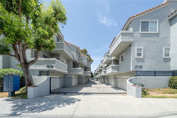 Front view of a multi-story residential building with gated entry.