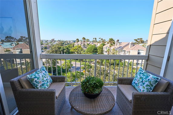 View from a balcony overlooking residential houses and greenery.