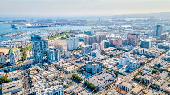 Aerial view of a coastal city with numerous buildings and a harbor area.