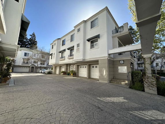 Front view of a multi-story building with garages on the ground level.