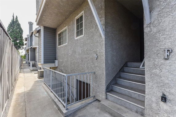 Entrance view of a multi-story building with stairs leading to a doorway.