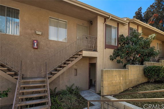 Front view of a two-story apartment building with external stairs.