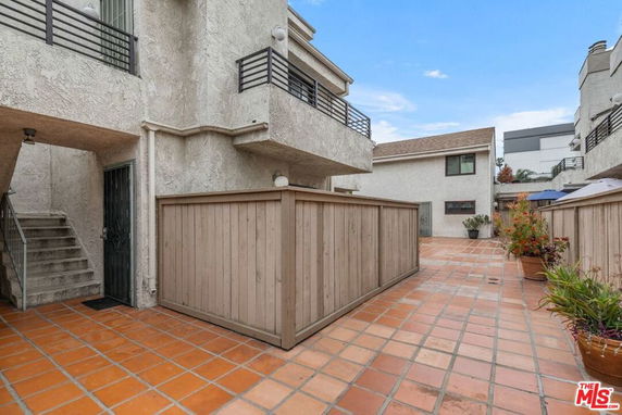 View of a residential building with terracotta tiles and wooden fences.