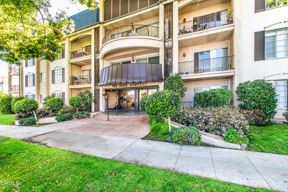 Front view of a multi-story apartment building with a covered entrance.