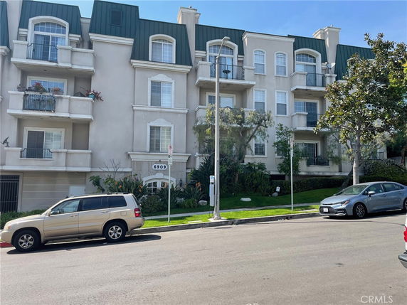 Front view of a multi-story apartment building with balconies.