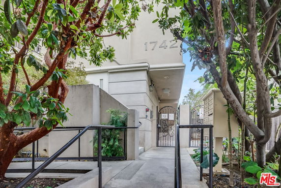 Front view of a building entrance with a pathway and gate.