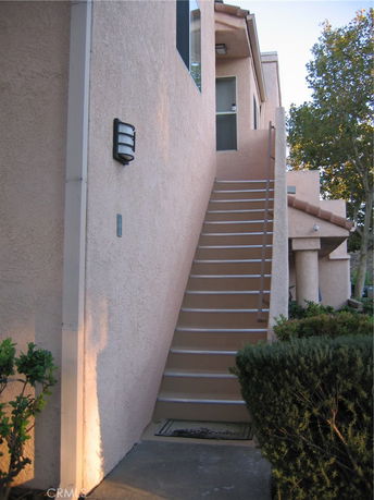 Front view of a multi-story house with an external staircase.