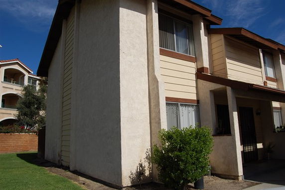 Front view of a two-story house with a simple beige exterior.