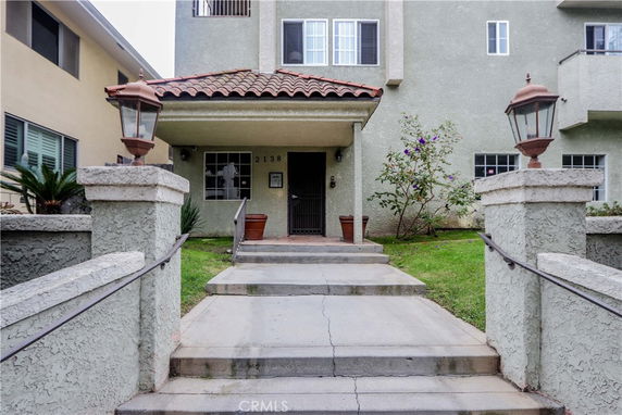 Front view of a multi-story house with an entrance and pathway.