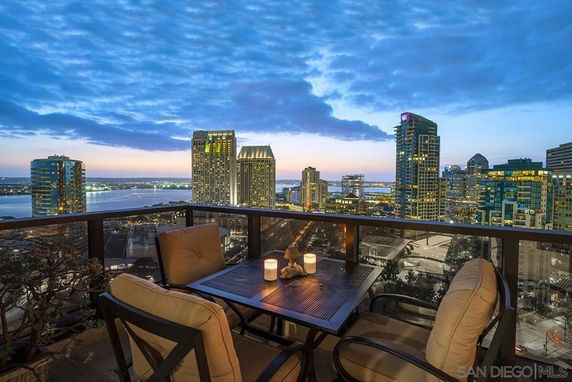 Panoramic view from a balcony overlooking a city skyline at dusk.