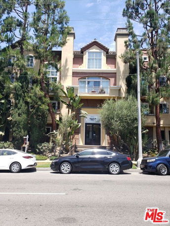 Front view of a multi-story residential building with a symmetrical design.