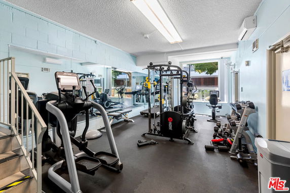 Indoor gym area with exercise equipment and mirrors.