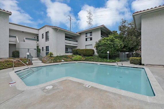 Outdoor swimming pool surrounded by residential buildings.
