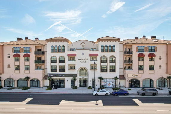 Front view of a multi-story building named Madison Place with retail spaces on the ground floor.