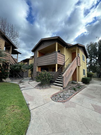 Front view of a two-story residential building with stairs leading to the upper floor.