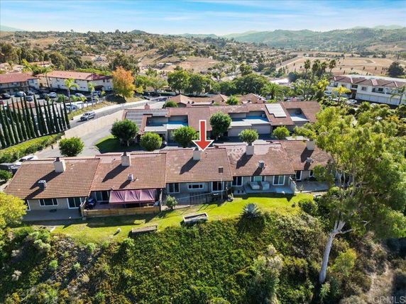 Aerial view of a residential area with multiple houses, showcasing a hillside setting.