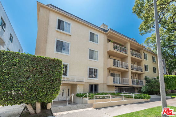 Front view of a multi-story apartment building with multiple balconies.