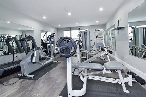 Interior view of a gym with various exercise equipment, including treadmills and weight machines.