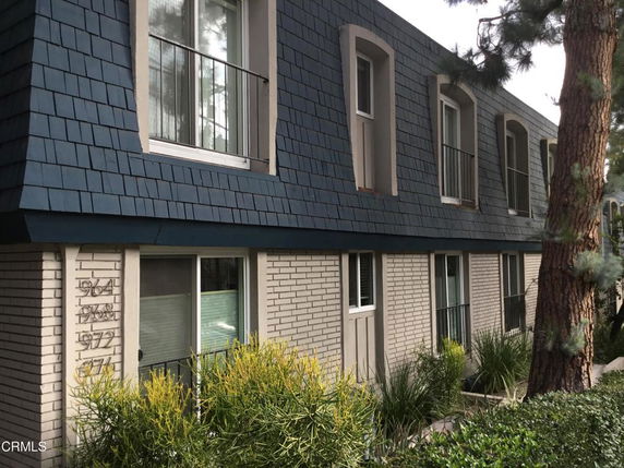 Front view of a two-story building with blue shingle exterior and multiple windows.